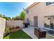 Private backyard patio featuring a grill, artificial grass, a sliding glass door and a seating area, ideal for outdoor enjoyment at 509 Chestnut View Pl, Henderson, NV 89052