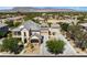 Expansive aerial view of a two-story home with a long driveway, detached garage, and mountain views at 5128 Blissful Valley Cir, Las Vegas, NV 89149