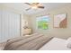 Bright bedroom with plush bedding, a modern ceiling fan, and a view of the outdoors at 5128 Blissful Valley Cir, Las Vegas, NV 89149