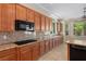 Spacious kitchen with granite countertops, wooden cabinets, and modern black appliances at 5128 Blissful Valley Cir, Las Vegas, NV 89149