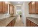 Well-lit butler's pantry with granite countertops and ample wooden cabinet storage space at 5128 Blissful Valley Cir, Las Vegas, NV 89149