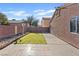 A cozy backyard features a small grassy area, concrete patio, and a brick wall for privacy at 5184 Mineral Lake Dr, Las Vegas, NV 89122