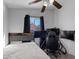 Cozy bedroom features a bed, a ceiling fan, and a comfortable gaming chair at 5184 Mineral Lake Dr, Las Vegas, NV 89122