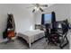 Cozy bedroom features a bed, a ceiling fan, and a comfortable gaming chair at 5184 Mineral Lake Dr, Las Vegas, NV 89122
