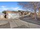 Charming single-story home with a wide driveway and a two-car garage under a blue sky at 5184 Mineral Lake Dr, Las Vegas, NV 89122