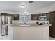 Spacious kitchen with dark cabinetry, granite counters, stainless appliances, and a convenient breakfast bar at 5184 Mineral Lake Dr, Las Vegas, NV 89122