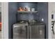 Convenient laundry area with a washer, dryer, and shelving for storage at 5184 Mineral Lake Dr, Las Vegas, NV 89122