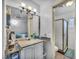 Bright bathroom featuring a white vanity, decorative mirror, and tiled walk-in shower at 54 Del Amo Dr, Las Vegas, NV 89110