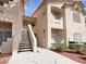 A three-story condo features stairs, balconies and landscaped yard with mulch in a desert setting at 5415 W Harmon Ave # 2048, Las Vegas, NV 89103