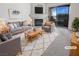 Staged living room with modern furniture, a fireplace and large sliding doors to a sunny patio at 5415 W Harmon Ave # 2048, Las Vegas, NV 89103