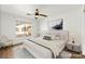 Staged bedroom with a ceiling fan, complemented by a cozy chair and a window offering outside views at 6029 Mustang Breeze Trl # 101, Henderson, NV 89011