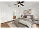 Cozy staged bedroom featuring plush bedding, ceiling fan, and a connecting bathroom at 6029 Mustang Breeze Trl # 101, Henderson, NV 89011