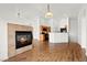 Open-concept space with fireplace and wood-look floors flowing into a kitchen, creating a welcoming atmosphere at 6029 Mustang Breeze Trl # 101, Henderson, NV 89011