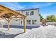 Backyard with large stone-paved patio, pergola, swing set, and lush greenery at 6313 Giant Oak St, North Las Vegas, NV 89084