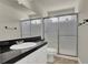 Bathroom featuring a single sink, black granite countertops, a walk-in shower, and tile floors at 6313 Giant Oak St, North Las Vegas, NV 89084