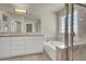 Bathroom featuring a soaking tub, double vanity, and glass-enclosed shower at 6313 Giant Oak St, North Las Vegas, NV 89084