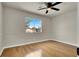 Bedroom with hardwood floors, light gray walls, large window, and ceiling fan at 6313 Giant Oak St, North Las Vegas, NV 89084
