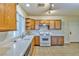 Functional kitchen with white countertops, tile backsplash, wooden cabinets, and essential appliances for cooking and meal preparation at 6381 Pronghorn Ridge Ave, Las Vegas, NV 89122