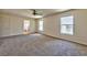 Large main bedroom with neutral carpeting, windows, and an ensuite bathroom, providing a private and relaxing retreat at 6381 Pronghorn Ridge Ave, Las Vegas, NV 89122