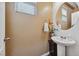 Elegant half-bathroom featuring a pedestal sink and ornate mirror at 6409 Dundock Ave, Las Vegas, NV 89122