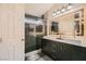 Modern bathroom with double vanity, quartz countertop, a large lighted mirror, and glass shower at 6424 Strongbow Dr, Las Vegas, NV 89156