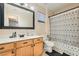 Bathroom featuring wood cabinets, decorative mirror, and shower with black and white patterned curtain at 6424 Strongbow Dr, Las Vegas, NV 89156