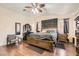 Spacious primary bedroom with a wood bed frame, hardwood floors, fan and vanity at 6424 Strongbow Dr, Las Vegas, NV 89156
