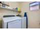 Convenient laundry room with modern washer and dryer, plus storage shelving for added organization at 6424 Strongbow Dr, Las Vegas, NV 89156