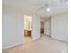 Bright bedroom with neutral carpet, ceiling fan, and attached bathroom at 7363 San Pablin St, Las Vegas, NV 89139