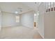 Open living area with carpet, fan, and second story view of the entry staircase at 7363 San Pablin St, Las Vegas, NV 89139