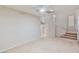 Spacious living room with neutral carpet, leading to a staircase with white railing and natural light at 7363 San Pablin St, Las Vegas, NV 89139