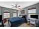 Cozy bedroom featuring carpet floors, a ceiling fan, and two large windows at 7486 Benlomond Ave, Las Vegas, NV 89179