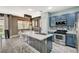 Open kitchen with stainless steel appliances, tile backsplash, island with seating and pendant lighting at 7486 Benlomond Ave, Las Vegas, NV 89179