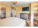 Bedroom with hardwood flooring, ceiling fan, TV, closet and ensuite bathroom entrance at 7491 Speedwell Cavern St, Las Vegas, NV 89139