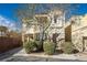 Inviting two-story home featuring a neutral color scheme, manicured bushes, and a quaint front porch at 7491 Speedwell Cavern St, Las Vegas, NV 89139