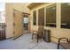 A comfortable patio setting includes chairs and a trashcan on light colored paving at 7491 Speedwell Cavern St, Las Vegas, NV 89139