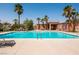 Community pool surrounded by palm trees and lounge chairs at 7491 Speedwell Cavern St, Las Vegas, NV 89139