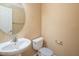 Powder room featuring single sink vanity, toilet and round mirror at 7491 Speedwell Cavern St, Las Vegas, NV 89139