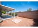 Spacious backyard featuring a covered patio, brick accents, and a cozy tile section at 7500 Peaceful Brook St, Las Vegas, NV 89131