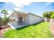Exterior view of a home with a covered patio, lush green lawn, and privacy fence at 7500 Peaceful Brook St, Las Vegas, NV 89131