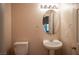 Half bathroom featuring a pedestal sink and oval mirror at 7500 Peaceful Brook St, Las Vegas, NV 89131
