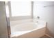 Bright bathroom featuring an inviting, tiled soaking tub under a window for natural light at 7500 Peaceful Brook St, Las Vegas, NV 89131