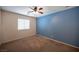 Bedroom with carpeted floors, ceiling fan, and a blue accent wall at 7500 Peaceful Brook St, Las Vegas, NV 89131