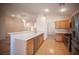 Open kitchen with wood floors and stainless steel appliances overlooking dining area at 7500 Peaceful Brook St, Las Vegas, NV 89131