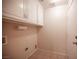Well-lit laundry room with overhead cabinets, tiled floors and washer and dryer hookups at 7500 Peaceful Brook St, Las Vegas, NV 89131