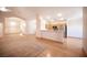 Bright and airy living space that blends carpet and wood floors leading to kitchen at 7500 Peaceful Brook St, Las Vegas, NV 89131