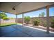 Covered patio with desert landscaping, greenery, and brick trim in the backyard at 7500 Peaceful Brook St, Las Vegas, NV 89131