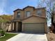Two-story tan home with a two car garage, front landscaping, and a driveway at 7788 Soda Canyon St, Las Vegas, NV 89139
