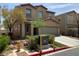 Two-story tan home with a two car garage, driveway and green landscaping at 7788 Soda Canyon St, Las Vegas, NV 89139