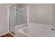 Modern bathroom featuring a glass-enclosed shower and a soaking tub at 7905 Idledale Ct # 102, Las Vegas, NV 89145